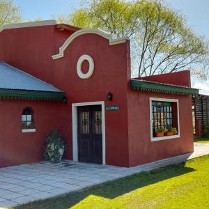 乌拉圭河畔康塞普西翁La Cipriana的前面有一扇门的红色房子
