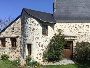 Souvigné-sur-SartheGîte Souvigné-sur-Sarthe, 3 pièces, 5 personnes - FR-1-410-191的一座石头房子,设有黑色屋顶和车库