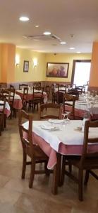 PomarEL RINCON DE TOÑO的餐厅内带桌椅的用餐室