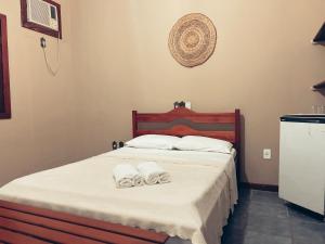普拉杜Pousada Pitanga的一间卧室配有带毛巾的床