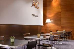 阿尔卡拉德荷那利斯AC Hotel Alcalá de Henares by Marriott的餐馆里的一组桌椅