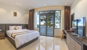大叻Rung La Kim Resort的一间卧室配有一张床和一张书桌及电视