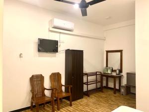 达瓦拉维Imperial Resort的客厅配有2把椅子和平面电视