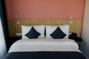 奇姆肯特Graf Hotel的一间卧室配有一张大床,提供黑白枕头