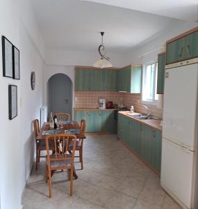 KatokhórionVivis house的厨房配有绿色橱柜和桌椅