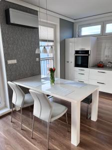 科希策Monte Amnis Kosice Apartment的白色的厨房配有白色的桌子和椅子