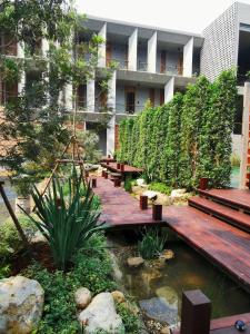 清迈Proud Phu Fah Muang Chiang Mai的一座花园,在一座建筑前设有长椅和池塘