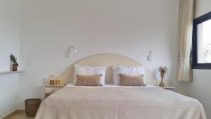 阿拉德Desert Call的白色卧室配有一张带两个枕头的大床