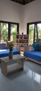 塞莱马德加Villa Gede Private Guest House的客厅配有两张床和茶几