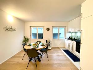 利斯塔尔GLAD Spot - Liestal - 10 min from Basel - Central, Design & Netflix的厨房以及带桌椅的用餐室。