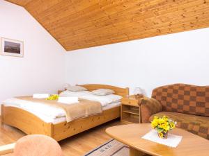 斯托拉Villa Tatry Stola的一间卧室配有一张床、一张沙发和一张桌子