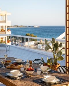 雅典Sea View Beach Penthouse - Athens Coast的阳台上的木桌和食物