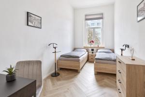 卡罗维发利Apartment Nicol的客房设有两张床、一张桌子和一个窗户。
