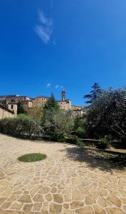 Serra San QuiricoFontecorona Bed and Breakfast的石头庭院,后面有一座建筑