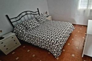 贝赫尔-德拉弗龙特拉Casa Lucas的一间卧室配有一张带黑白色棉被的床