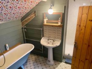 牛顿阿伯特Corndonford farm的浴室配有盥洗盆和浴缸。