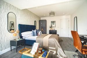赫默尔亨普斯特德Hemel Apartments- Elite Escape的一间卧室配有一张大床、一张桌子和一张书桌
