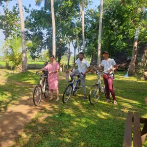 阿努拉德普勒Monara Arana Farm Resort的一群人站在公园里骑着自行车