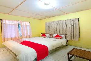 巴拉巴特OYO 92503 Penginapan & Villa Sirait的一间卧室配有红色和白色床单