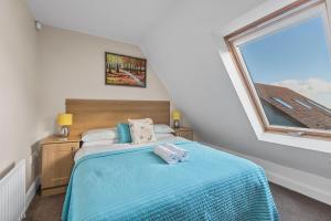 纽卡斯尔Tollyrose Country House的一间卧室配有一张带蓝色床单的床和一扇窗户。