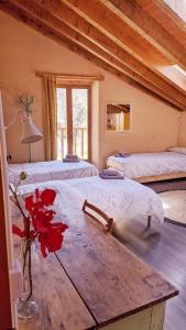 VíoCasa Rural Petricor, Ordesa的一间设有三张床和一张花瓶桌子的房间