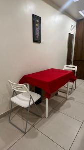 维沙卡帕特南Royal Villa Guest House的红色的桌子和椅子,上面有红色的桌布