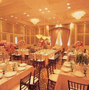 查尔斯顿市场廷苑酒店的宴会厅配有白色的桌椅和鲜花