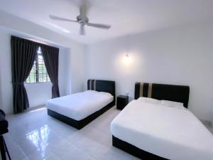 卢穆特Venice Guest Hostel - Bilik Sahaja的酒店客房配有两张床和吊扇。