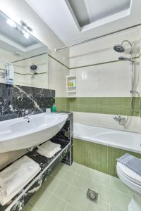 拉加纳斯Majestic Hotel & Spa的一间带水槽、浴缸和卫生间的浴室