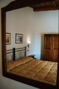 蒙特普齐亚诺Villa Nottola的卧室内的镜子反射着一张床