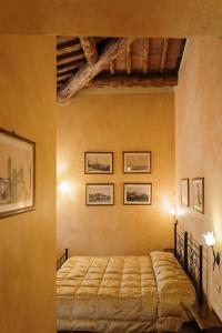 蒙特普齐亚诺Villa Nottola的卧室配有一张床,墙上挂有图片