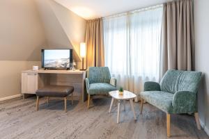 UtersumWaastwinj - 500m vom Strand的酒店客房配有2把椅子、书桌和电视。