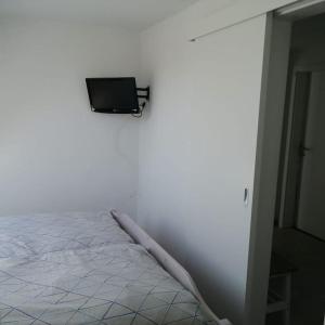 费马恩Ferienwohnung Leuchtturmkieker in Schlagsdorf auf Fehmarn的白色的客房设有一张床和墙上的电视