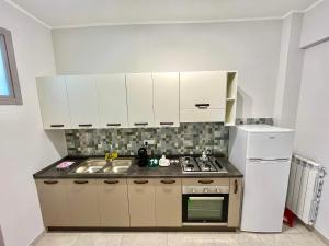 那不勒斯Apartment NAPOLI MARADONA的厨房配有白色橱柜、炉灶和冰箱。
