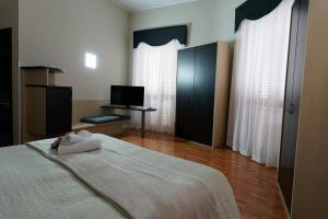 墨西拿Hotel Sant'Elia的一间卧室配有一张大床和电视