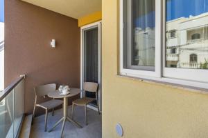 马尔萨斯卡拉Sandstone A8 Marsascala - 15minute drive to Valletta的阳台配有桌椅和窗户。
