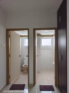 云顶高原15-18 Pax Deluxe Family Room 3R2B,Cloudview,Mountain View, Golden Hills Resort , Genting Highlands的浴室设有2扇开放式门和卫生间。