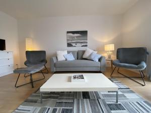 胡苏姆Simmerdeis am Hafen的客厅配有沙发和两把椅子
