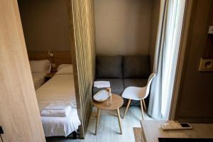 PradoluengoCAMPING RESORT LA TRAPERA的小房间设有床、桌子和镜子