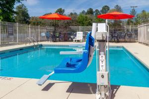 奥古斯塔La Quinta Inn & Suites by Wyndham Augusta Fort Eisenhower的一个带滑梯和遮阳伞的游泳池