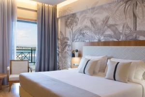 马蒂Ramada by Wyndham , Athens Club Attica Riviera的酒店客房设有一张床和一个阳台。