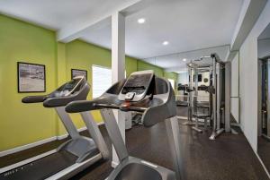 休斯顿Baymont by Wyndham Houston/Westchase的健身房设有两台跑步机和绿色墙壁