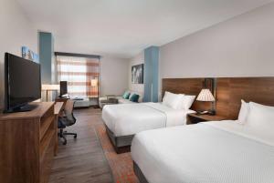 威斯康星戴尔La Quinta Inn & Suites by Wyndham Wisconsin Dells- Lake Delton的酒店客房设有两张床和一台平面电视。