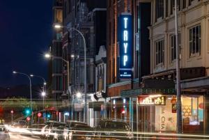 惠灵顿TRYP by Wyndham Wellington, Tory Street的繁忙的城市街道,晚上有汽车和灯