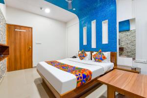艾哈迈达巴德FabHotel Raj Ratna, Ahmedabad的一间卧室配有一张床和一张木桌
