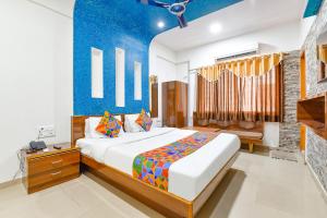 艾哈迈达巴德FabHotel Raj Ratna, Ahmedabad的一间卧室设有一张床和蓝色的墙壁