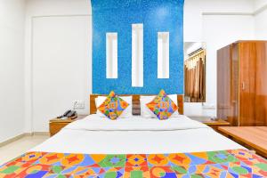 艾哈迈达巴德FabHotel Raj Ratna, Ahmedabad的一间卧室设有一张蓝色墙壁的大床