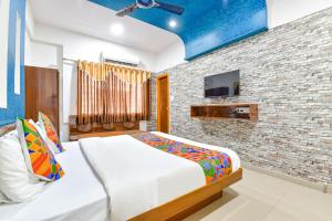 艾哈迈达巴德FabHotel Raj Ratna, Ahmedabad的一间卧室设有一张床和砖墙