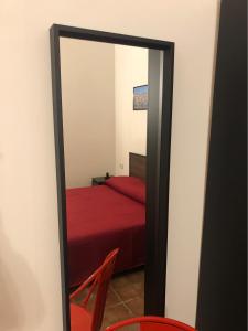 塔兰托Downtown Lodge Museum的配有红色床的客房内的镜子
