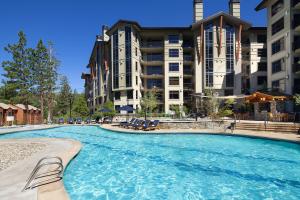 马姆莫斯湖猛犸湖威斯汀莫纳奇度假酒店的大楼前带椅子的大型游泳池